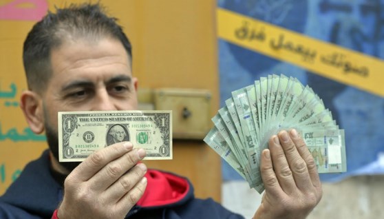 مواطن سوري يرفع الدولار والليرة