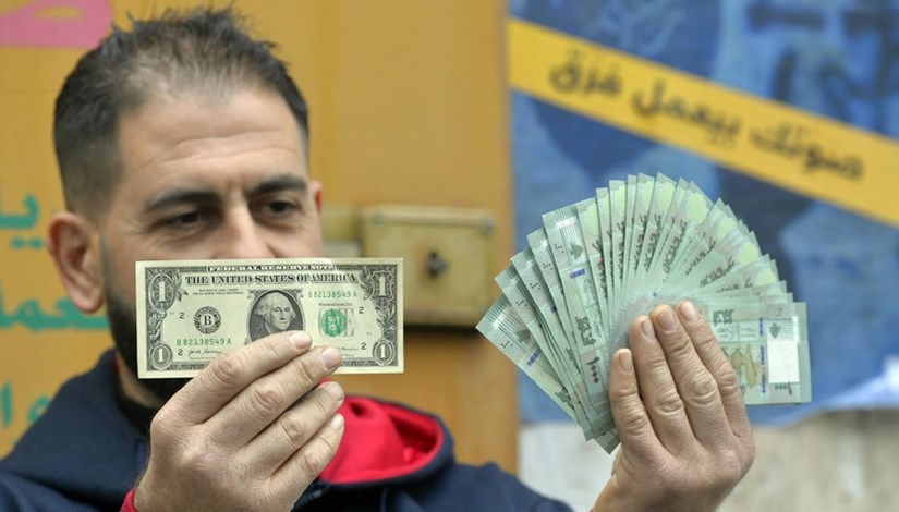 مواطن سوري يرفع الدولار والليرة مواطن سوري يرفع الدولار والليرة