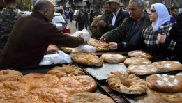 سوريون يشترون مخبوزات من أحد الأسواق