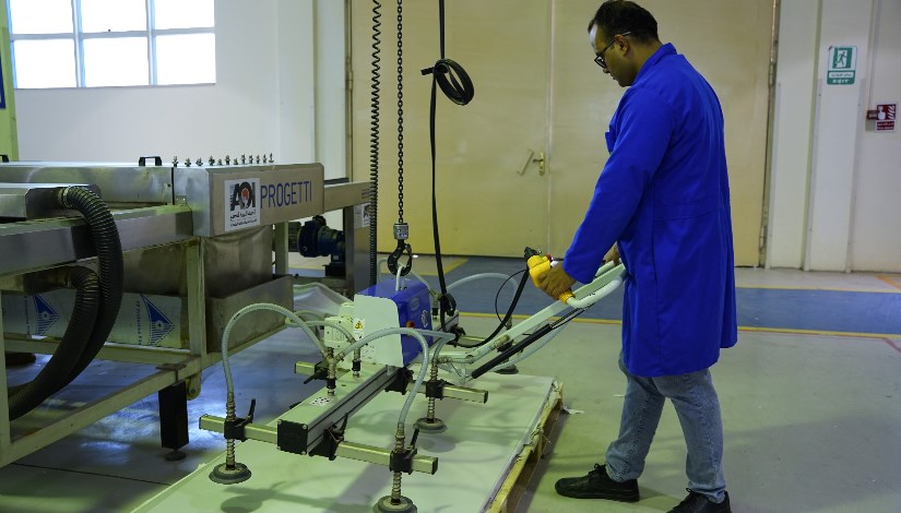 عامل يحمل ألواح الطاقة الشمسية بماكينة السحب