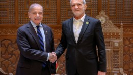 الرئيس الإيراني مسعود بزشكيان يصافح رئيس الوزراء الباكستاني شهباز شريف