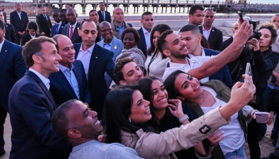 شباب في الاسكندرية يلتقطون صورة سيلفي مع الرئيس السيسي وماكرون